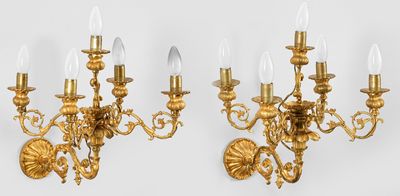 a pair of antique brass wall lights on a white wall