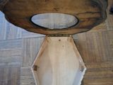 a person holding a piece of wood on top of a table