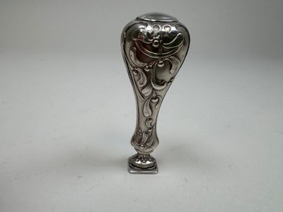 an antique silver spoon on a white table with a white background