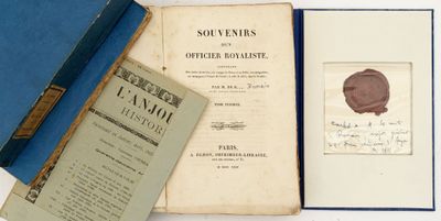 un vieux livre posé sur une table blanche, à côté d'un livre bleu