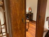 a wooden armoire with a mirror on it in a room