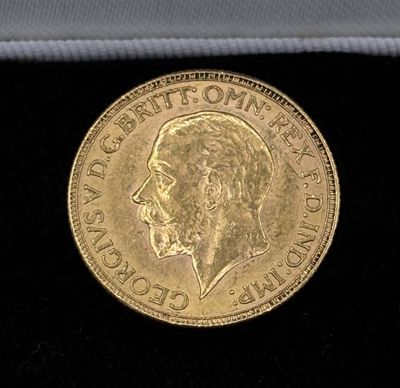 a close up of a gold coin on a black surface