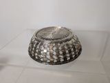 a glass display case with a silver bowl on it