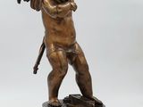 an antique bronze statue of a cupid holding a sword