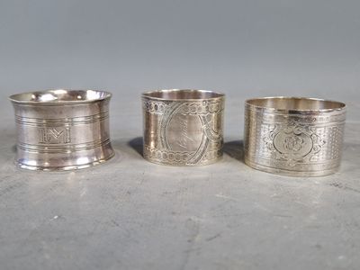 trois serviettes argentées ornées de motifs, posées sur une table