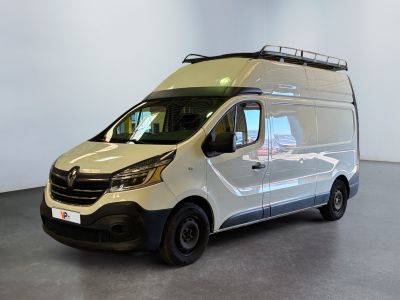 La camionnette blanche est garée dans une grande pièce équipée d'une galerie de toit.