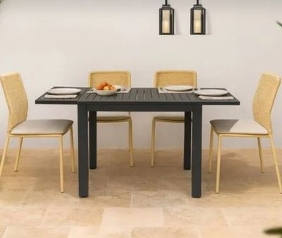 une table avec quatre chaises et un bol de fruits posé dessus