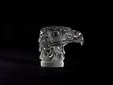 a glass sculpture of an eagle on a black surface