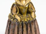 figurine représentant une femme assise sur une souche d'arbre