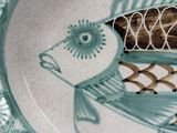 a plate with a fish design on it on a table