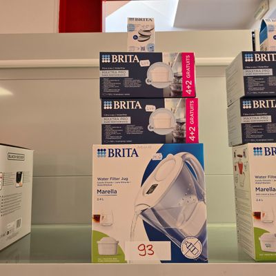 Plusieurs cartons de produits Brita sont empilés sur une étagère dans un magasin.