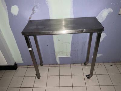 une table en acier inoxydable au milieu d'un sol carrelé