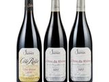 three bottles of wine are lined up on a white surface