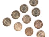 six different types of coins arranged in a triangle on a white surface
