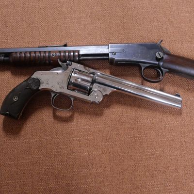 deux armes à feu posées sur une surface marron