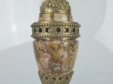 a gold vase with a bird on it on a table