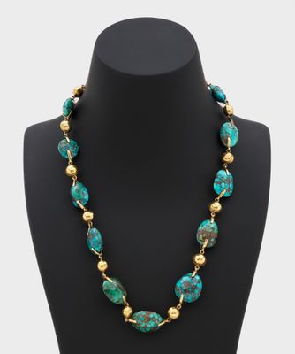 un collier composé de perles de turquoise et d'or, présenté sur un mannequin
