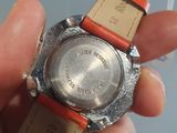 a person holding a wrist watch with a tag on it