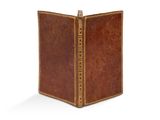 un vieux livre à la couverture brune et à la bordure dorée