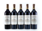 quatre bouteilles de vin sont alignées sur une surface blanche