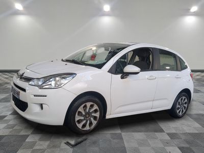 the small white car is parked on a checkered tile floor