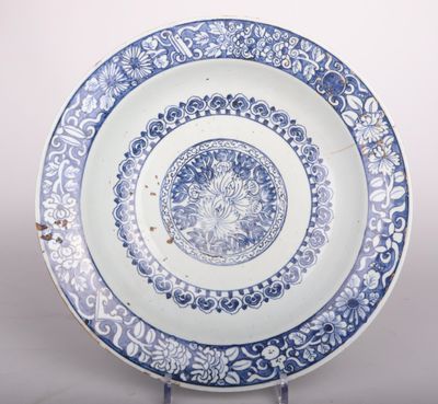 une photo d'une assiette bleue et blanche posée sur un socle