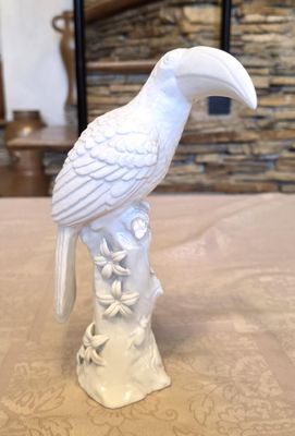 a white bird sitting on top of a tree stump