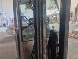 a forklift in a warehouse with a lot of wood