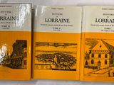 trois livres posés sur une surface blanche, avec le dessin d'un bâtiment