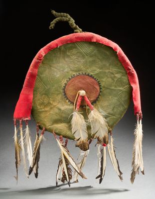 un tambour vert et rouge avec des plumes qui pendent sur le côté
