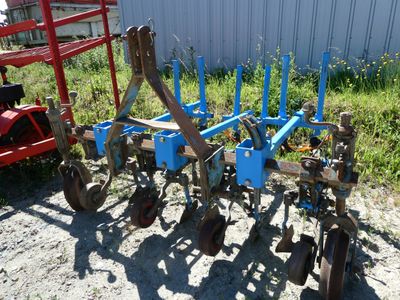 a blue plow that is sitting in the dirt