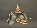 a black helmet with a gold top on a clear stand