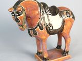 a figurine of a horse with a saddle on it ' s back