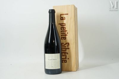 une bouteille de vin posée à côté d'une caisse en bois