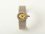 an antique ladies ' s watch with a yellow dial and diamond bezel