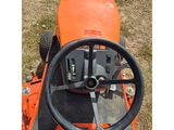 an orange tractor with a steering and steering wheel in the grass