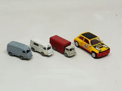 four toy cars sitting next to each other on a white surface