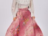 poupée Barbie en robe rose, avec un chemisier blanc et une jupe rose