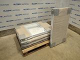 une pile de cartons et un matelas posés sur une palette devant un mur