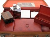 a brown suitcase with several different items inside of it