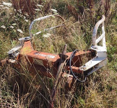 a rusted out tractor in the middle of a field