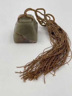 a stone and rope on a white surface