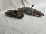 deux petits bateaux en plastique posés sur une surface blanche
