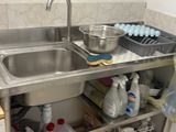 une cuisine avec un évier et un comptoir sur lequel se trouve de la vaisselle