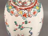 a vase with a lid that has flowers and birds on it