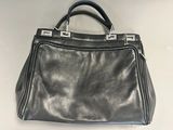 black leather handbag with metal handles on a white surface