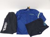 une veste bleue, un pantalon et un chapeau posés sur une surface blanche