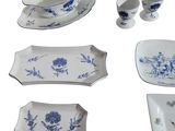 several pieces of blue and white porcelain dishes and cups on a white surface