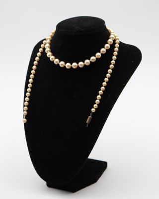 un gros plan d'un collier orné de perles porté par un mannequin