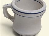 a white cup with a blue stripe on it